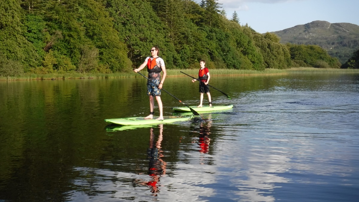 Two paddlers gliding along the shoreline