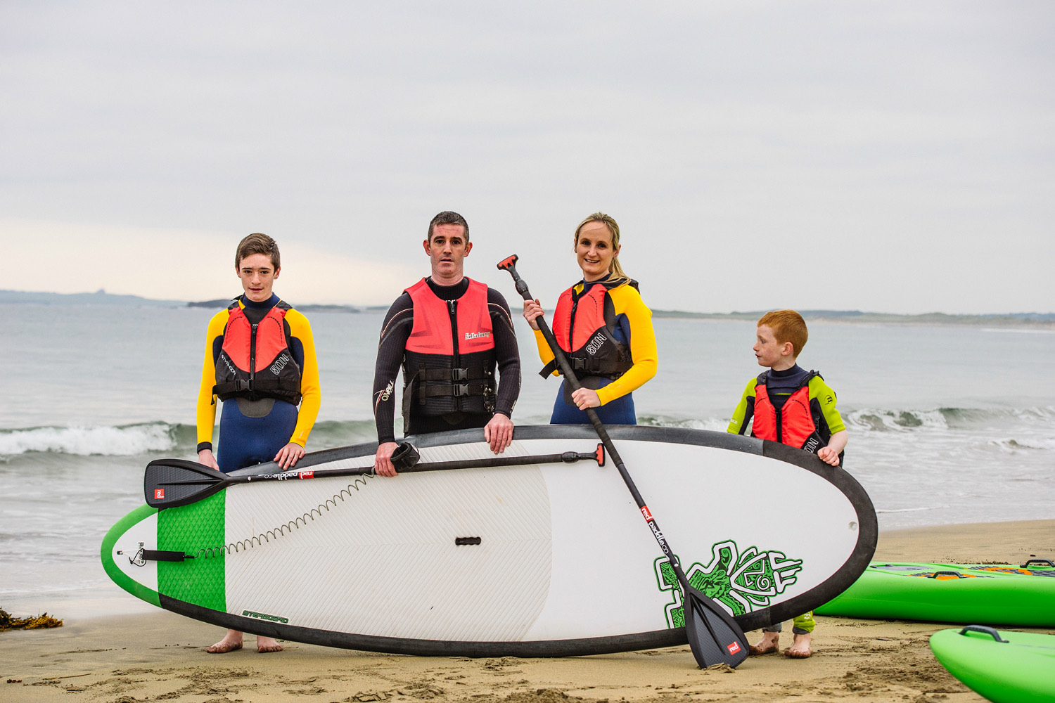 A family with paddleboards on the beach